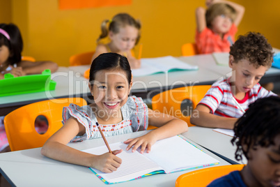 Portrait of smiling girl with book on bench