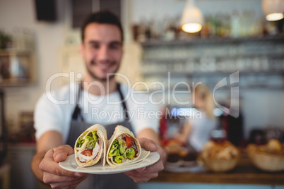 Waiter offering fresh rolls at cafe