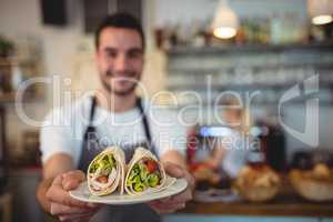 Waiter offering fresh rolls at cafe