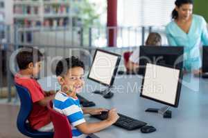 Boy with classmates and teacher during computer class