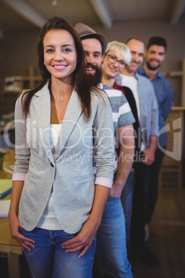 Happy coworkers standing in row at creative office