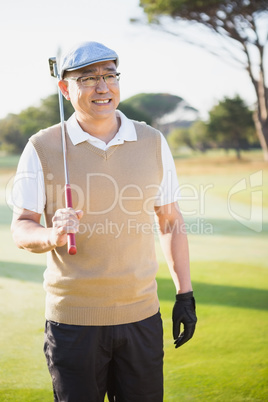 Portrait of sportsman holding his golf club and looking away