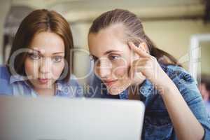 Close-up of businesswomen working on laptop in office