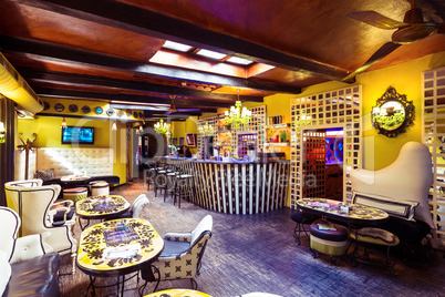 Tables and chairs in illuminated bar