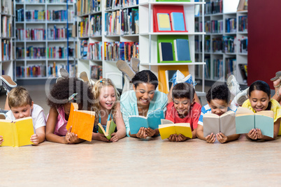 Teacher with students reading books while lying down