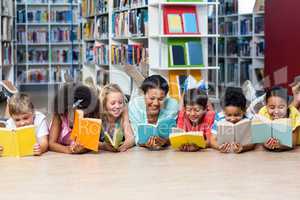 Teacher with students reading books while lying down