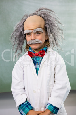 Portrait of boy dressed as scientist standing against board