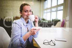 Smiling businesswoman having coffee