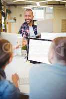 Businessman giving cup with drink to colleague in office