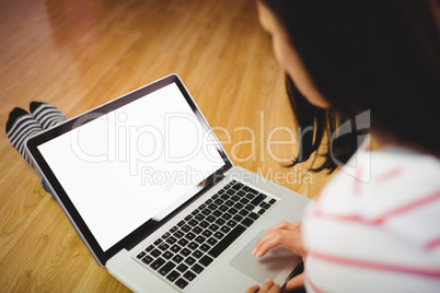 Woman using laptop on hardwood floor