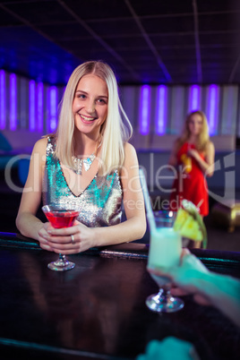 Young woman enjoying cocktail at bar counter