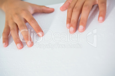 Cropped image of child touching braille book