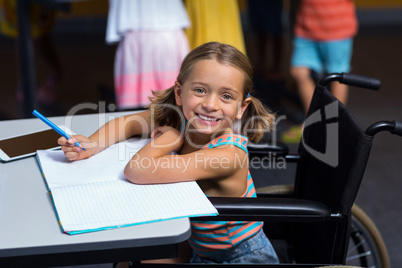 Little girl in wheelchair in classroom