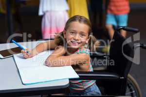 Little girl in wheelchair in classroom