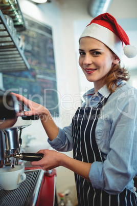 Portrait of waitress using coffee maker at cafeteria during Chri