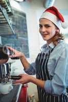Portrait of waitress using coffee maker at cafeteria during Chri