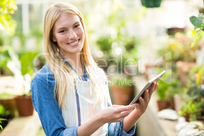 Smiling female gardener using digital tablet