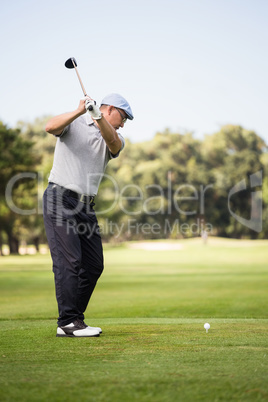Profile view of man playing golf