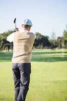 Rear view of sportswoman playing golf