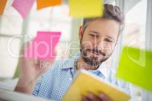 up of businessman writing on adhesive notes at office