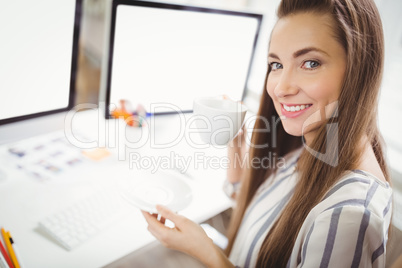 Portrait of businesswoman having coffee in creative office