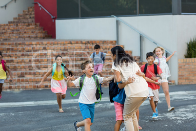 Happy children running towards teacher