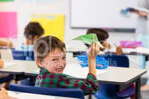 Cute boy holding paper airplane