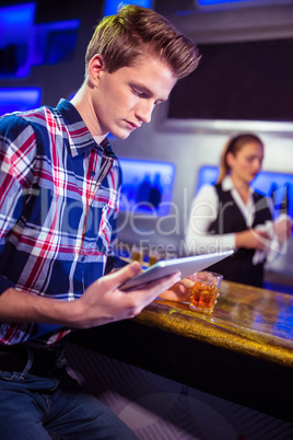 Man using digital tablet with bartender working