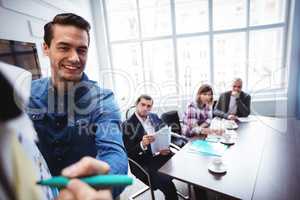 Smiling businessman writing on board