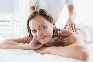 Portrait of woman receiving back massage from masseur