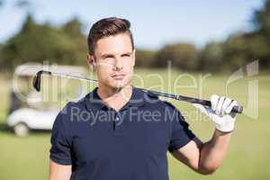 Confident young man carrying golf club