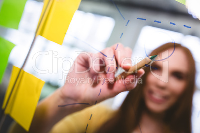 Businesswoman writing on glass