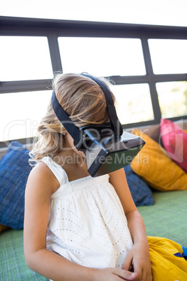 Girl using virtual reality headset while sitting in library