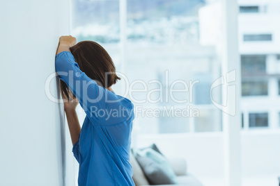 Sad woman standing by wall