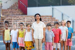 Portrait of happy female teacher with children