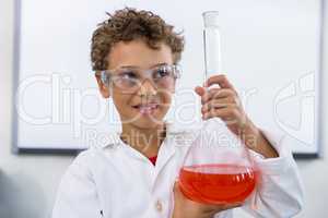 Boy holding flask with liquid at laboratory