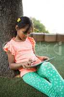 Girl using digital tablet at park