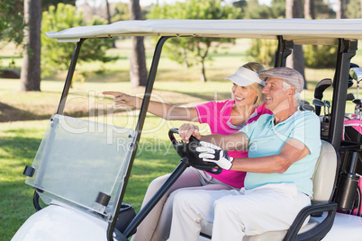 Smiling mature golfer woman showing to man