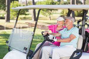 Smiling mature golfer woman showing to man