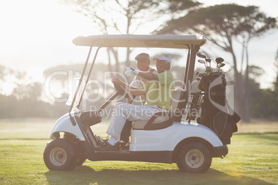 Mature golfer man pointing while sitting by friend