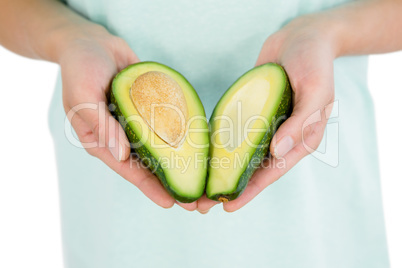 Woman holding avocado slices