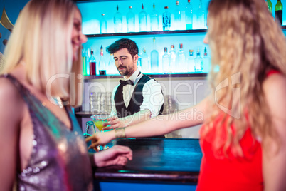 Bartender serving drinks to female customers