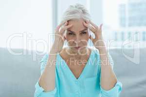 Portrait of senior woman suffering headache