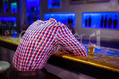 Rear view of man lying on bar counter