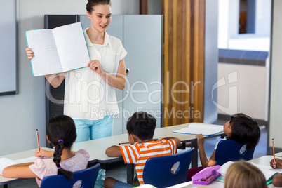 Teacher showing book with children