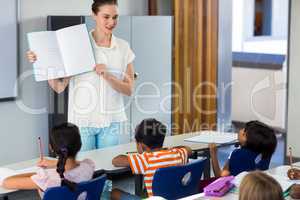 Teacher showing book with children