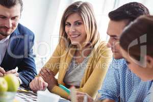 Smiling female photo editor with colleagues