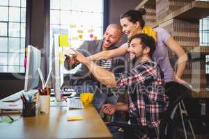 Cheerful business people pointing at computer