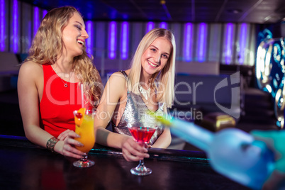 Young female friends enjoying drinks in nightclub