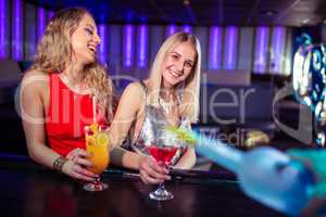 Young female friends enjoying drinks in nightclub